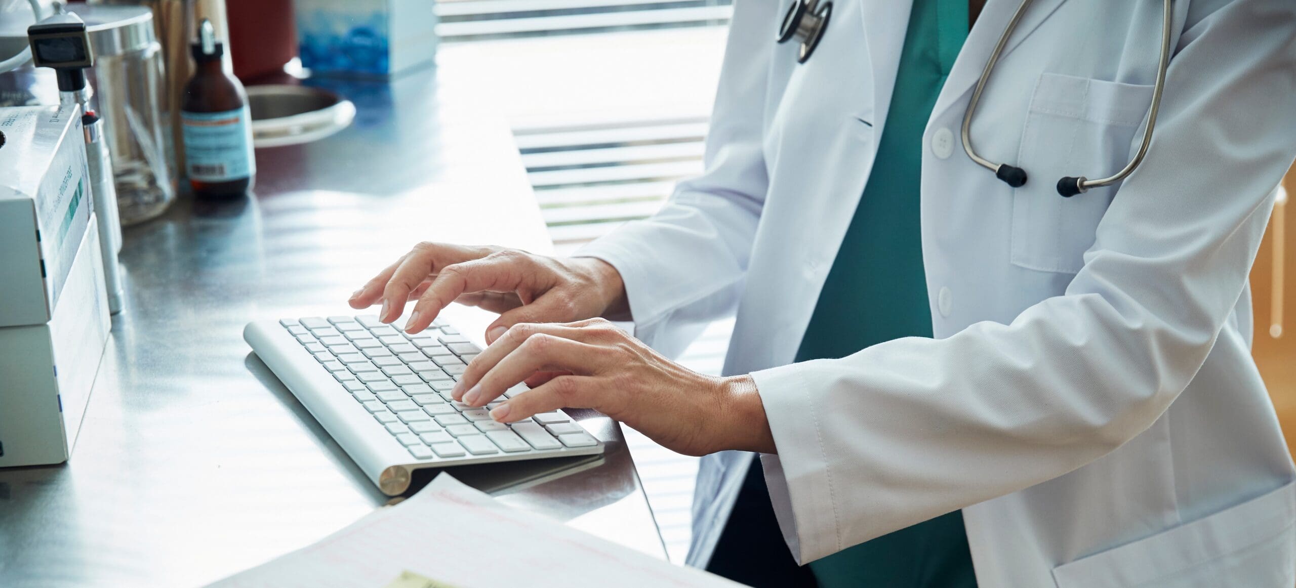 Doctor typing information on a keyboard