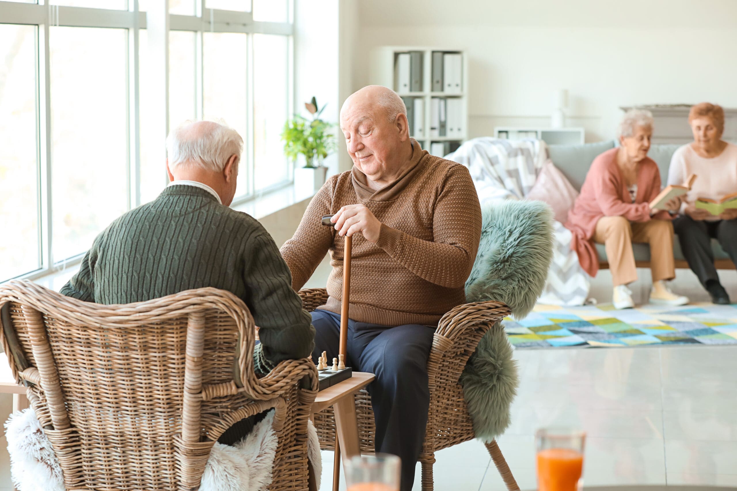 Senior men playing chess in nursing home