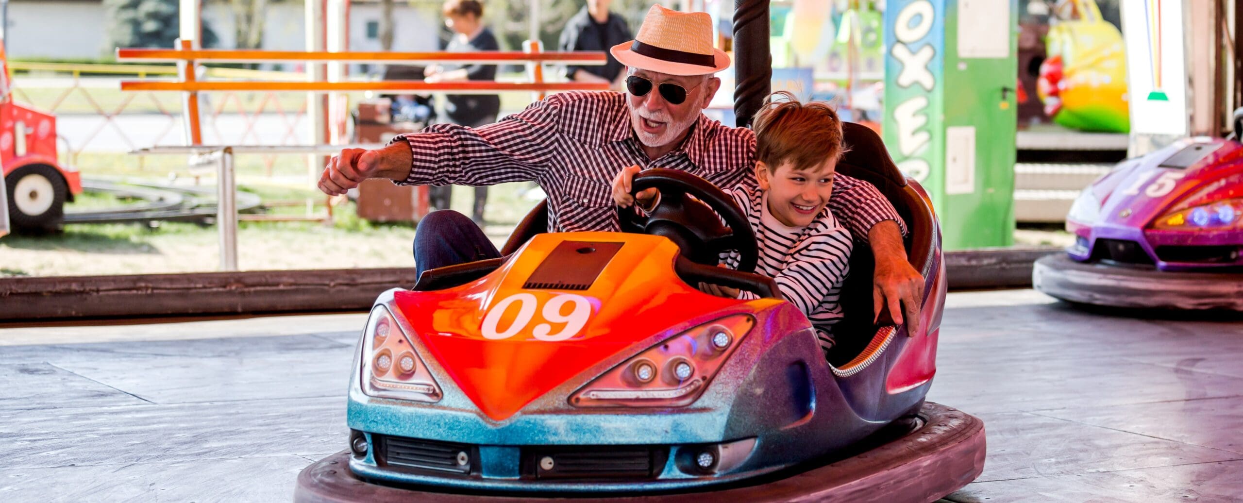Grandfather and grandson hawe fun in bumper car