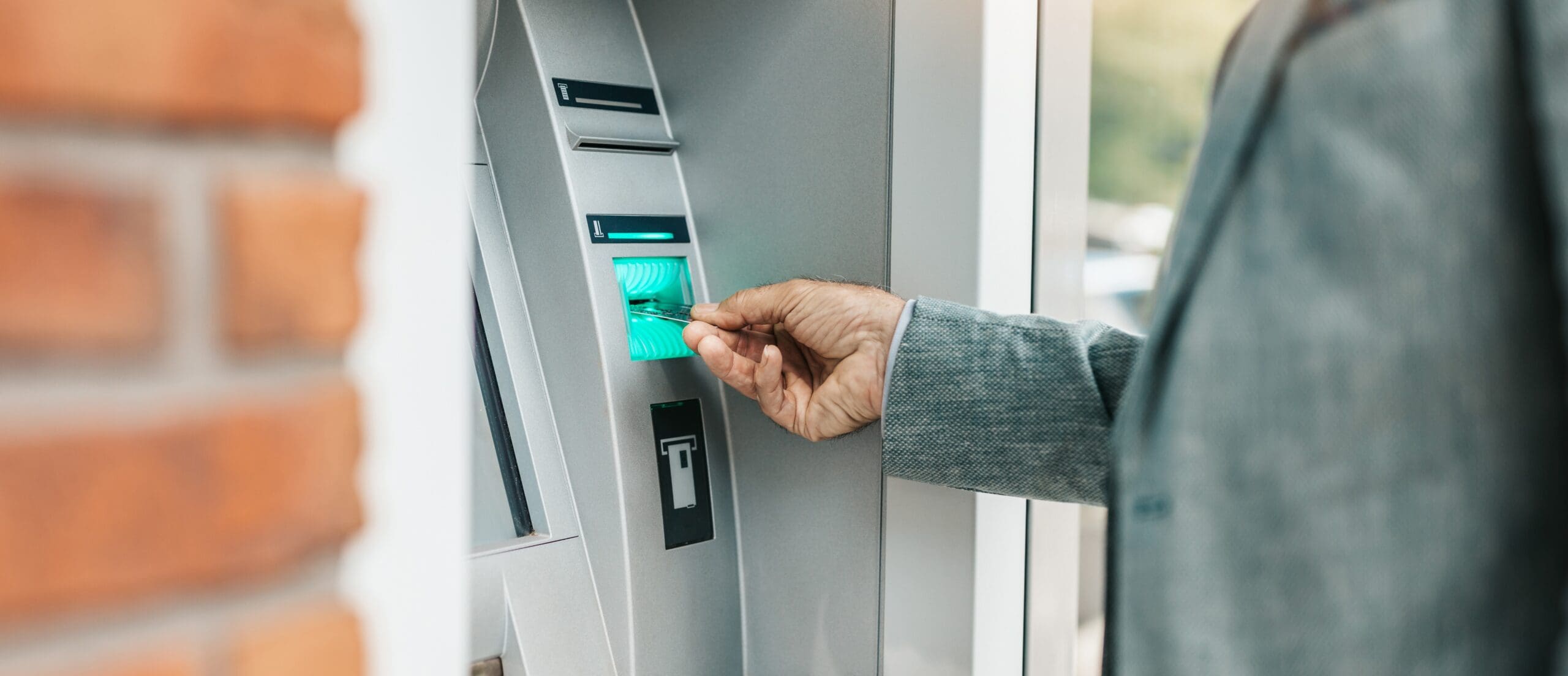 A senior man withdraws money from an automated teller machine (ATM).
