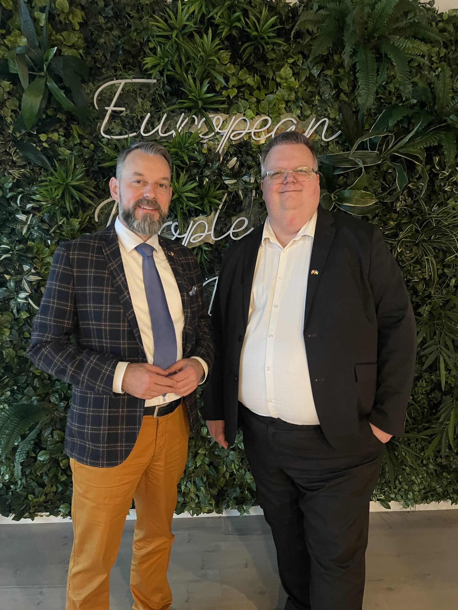 G&aacute;bor Berczeli, direkt&oslash;r for Robert Schuman Institute og Niclas Aarestrup fra KD foran noget gr&oslash;nt som ligner grene med blade p&aring;.